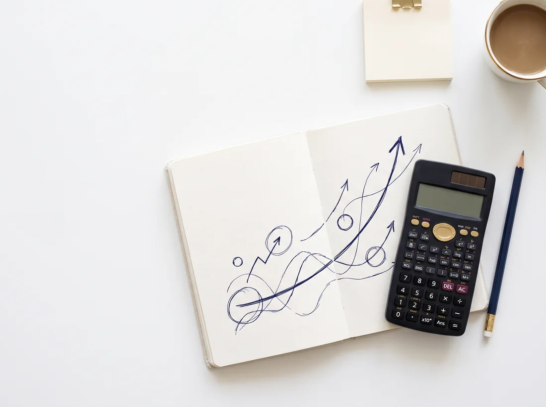 Escritorio con cuaderno de avances, calculadora y material de estudio